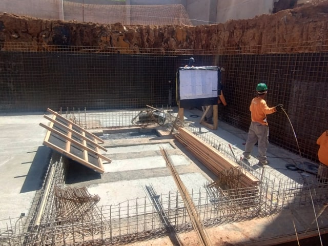 Instalação de malha de armação de aço para reforço estrutural de parede de contenção.